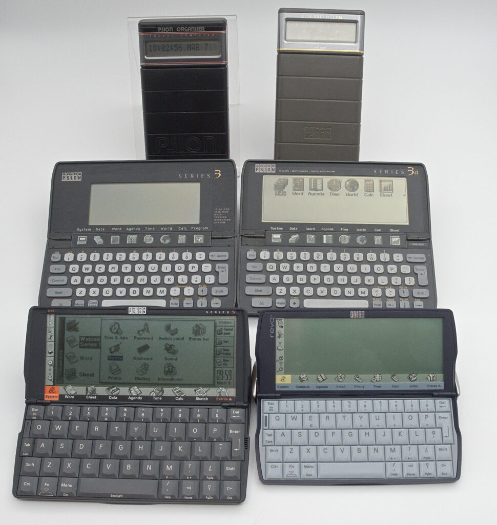 All the Psion PDAs in my collection, with the Organiser and Organiser II in the back, Series 3 and Series 3a in the middle and Series 5 and Revo in the front
